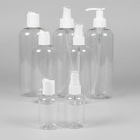 Set of clear plastic bottles with white caps on a grey background