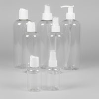 Set of clear plastic bottles with white caps on a grey background